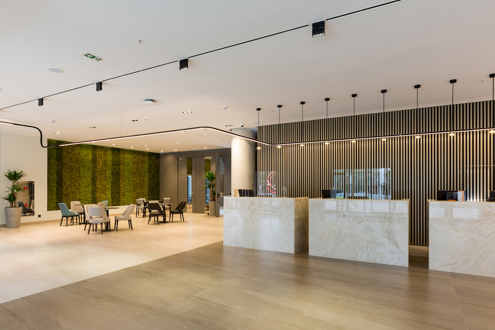 Interior of a hotel lobby with reception desks with transparent covid plexiglass lexan clear sneeze guards