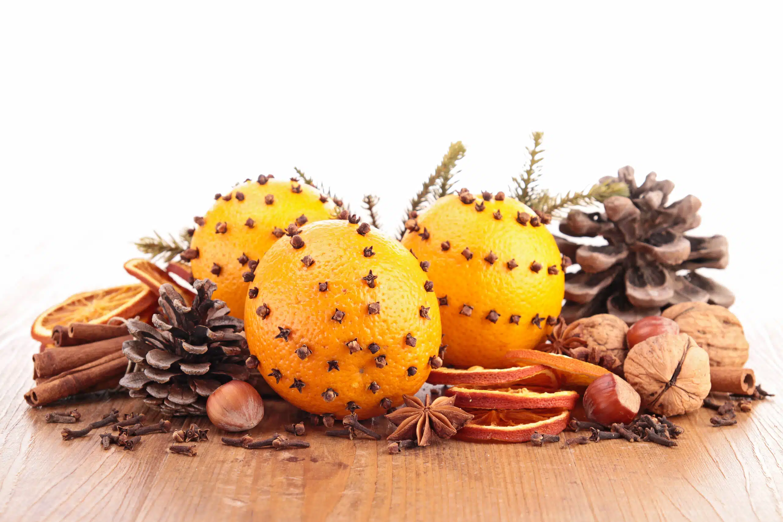 Winter Indoor Living: Ambient Scenting for Comfort & Mood A picture of oranges, cinnamon sticks, pine cones, walnutes, and orange slices sitting on a table