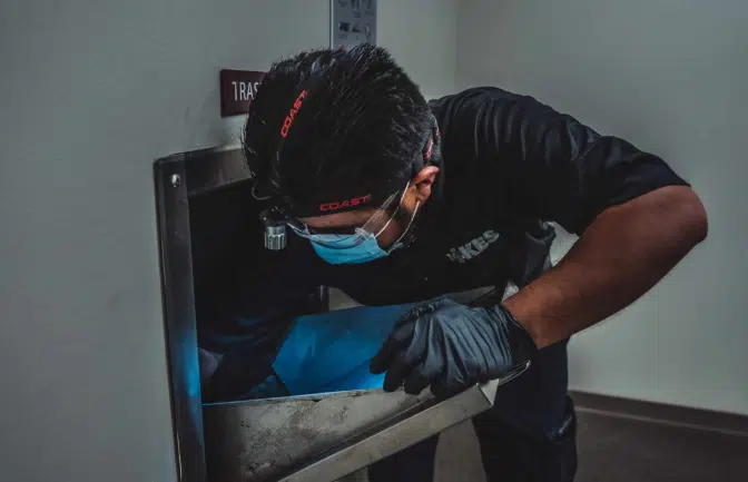 Why Early Spring Trash Chute Cleaning Is a Must for Every Property Fikes employee doing spring trash chute cleaning