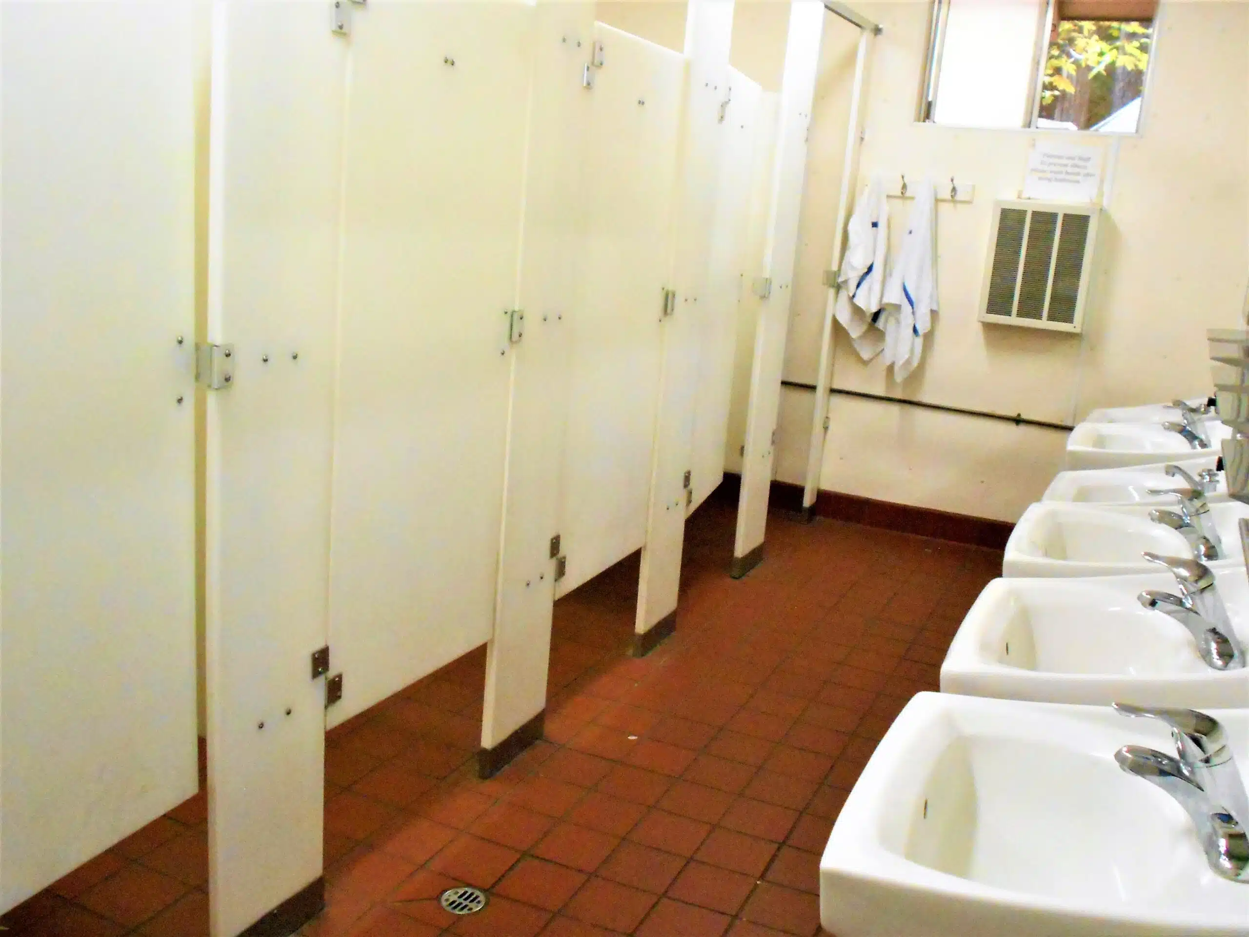 The Business Science of Long-Lasting Restroom Freshness A dirty public restroom with five stalls and five sinks in need of restroom freshness