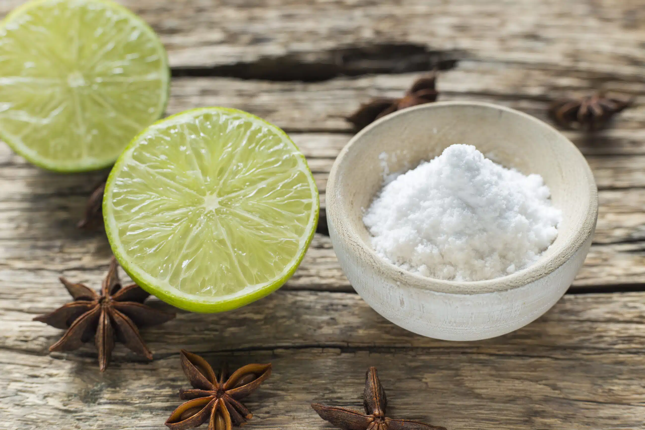 Summer Scent Marketing Strategies: How Heat Changes the Way Customers Smell Your Brand salt in a small bowl with lime halves and cardamom next to it on a wood table