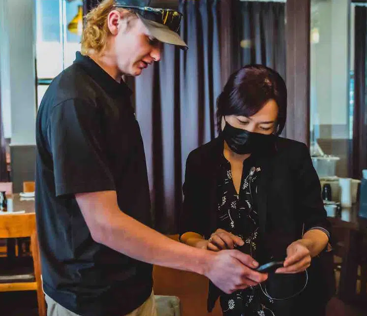 Summer Scent Marketing Strategies: How Heat Changes the Way Customers Smell Your Brand Fikes employee helping a customer with their scent diffuser on a phone