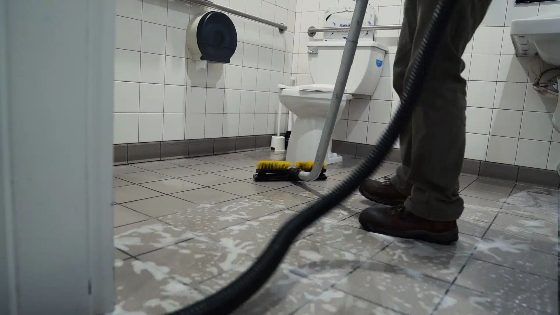 Facility Cold and Flu Prevention: Properly Preparing Manufacturer Restrooms person cleaning the floors of a restroom